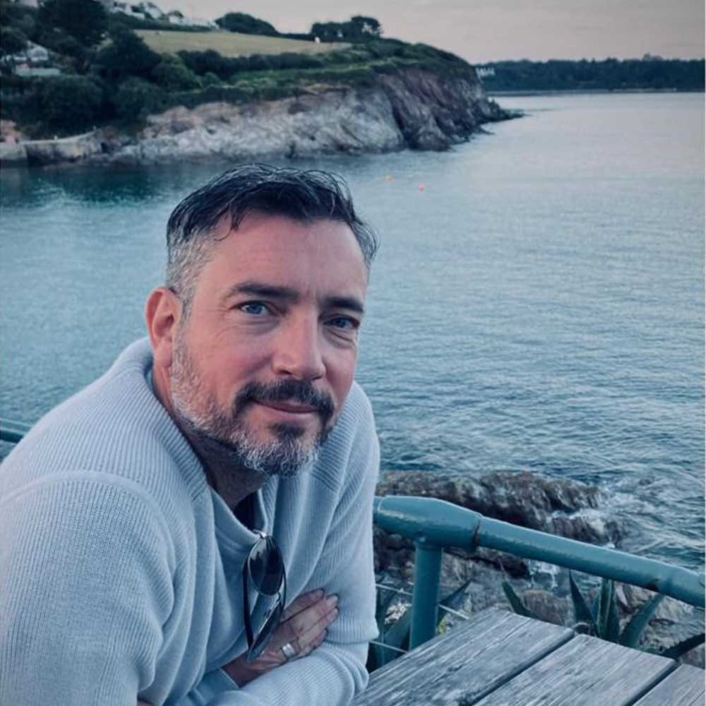 James, the real dad behind The Gifting Dad â smiling at a seaside table